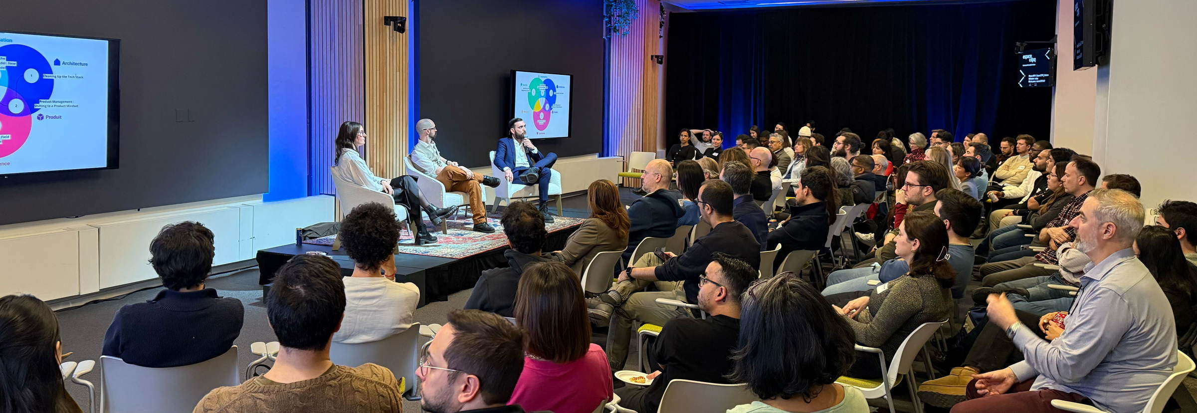 A full room watching a three-person panel at a Montreal community event held in partnership with ProductTank.